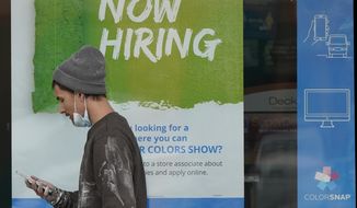 A man walks past a &amp;quot;Now Hiring&amp;quot; sign on a window at Sherwin Williams store, Friday, Feb. 26, 2021, in Woodmere Village, Ohio. Massive fraud in the nation's unemployment system is raising alarms even as President Joe Biden and Congress prepare to pour hundreds of billions more into expanded benefits for those left jobless by the coronavirus pandemic. (AP Photo/Tony Dejak)