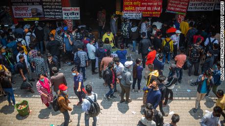 People wait to board a bus back to their home villages after new government restrictions in Kathmandu, Nepal, on April 27.