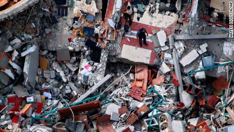 Palestinians inspect a destroyed building which housed media offices in Gaza City, after it was hit by an Israeli airstrike earlier in the week.