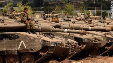An Israeli soldier sits on top of a tank at a staging ground near the border with Gaza on Friday following the ceasefire agreement.