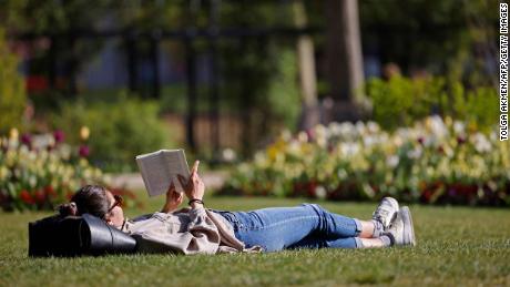 We can read, just as a woman reads a book on the grass in Hyde Park in London on April 23.