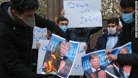 Students of Iran's Basij paramilitary force burn posters depicting Donald Trump and Joe Biden during at the foreign ministry in Tehran, on November 28, 2020, to protest the killing of prominent nuclear scientist Mohsen Fakhrizadeh a day earlier near the capital.