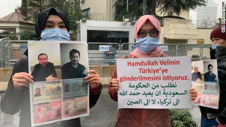 Nuriman Veli, second from left, and her sister protesting the disappearance of their father and his friend, pictured on the placard, outside Istanbul's Saudi consulate on February 12. CNN has blurred a portion of the photo to protect the men's personal details.