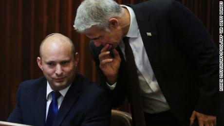 Right-wing Bennett described centrist Yair Lapid (R), his new coalition partner, as his friend. 