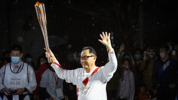 Toyoda runs with the Olympic torch during the Tokyo Olympic Games Torch Relay.