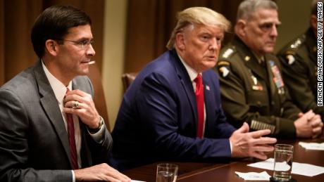 US Secretary of Defense Mark Esper (left), US President Donald Trump, and Chairman of the Joint Chiefs of Staff Army General Mark A. Milley (right) wait for a meeting with senior military leaders in the Cabinet Room of the White House in October 2019.