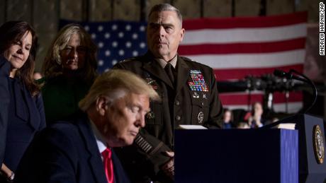 Joint Chiefs Chairman Gen. Mark Milley, top center, watches as President Donald Trump signs the National Defense Authorization Act for Fiscal Year 2020 at Andrews Air Force Base, Maryland, December 2019.