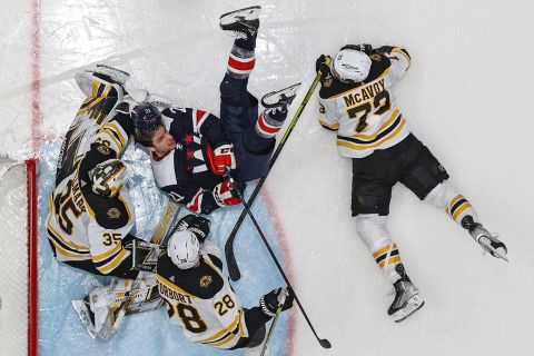 Washington's Garnet Hathaway collides with Boston goalie Linus Ullmark during an NHL game in Washington, DC, on Sunday, April 10.